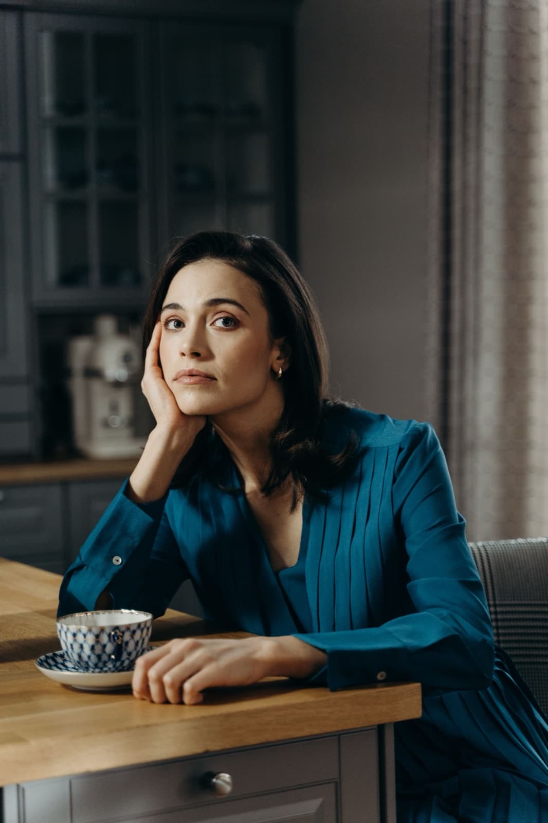 A woman pausing at her kitchen table